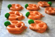 orange jellos with green candies sitting on top of a cookie sheet covered in icing