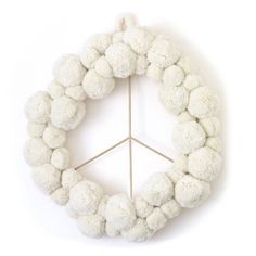 a white wreath with pom - poms on it