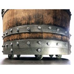 an old wooden barrel with metal wheels and rivets