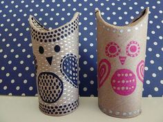 two decorated vases sitting on top of a table next to each other with polka dot wallpaper behind them