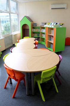 the children's table and chairs are arranged in an empty room with bookshelves