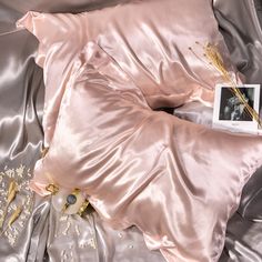 an image of a pink satin bed spread with flowers and pearls on the pillow cover