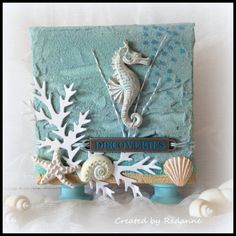 a close up of a small card with seahorses and seashells on it