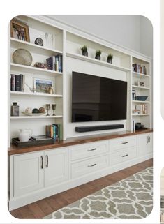 a living room with white bookcases and a flat screen tv on the wall