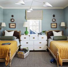 two twin beds in a bedroom with blue walls and checkered rugs on the floor