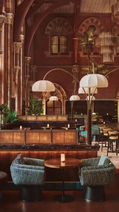 the inside of a restaurant with tables, chairs and chandeliers hanging from the ceiling