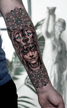 a man's arm with a lion tattoo on it and an ornate design in the middle