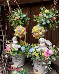 two white buckets filled with flowers and bunnies