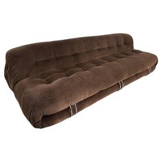 a brown futon sofa bed sitting on top of a white floor