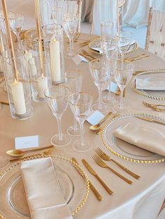 the table is set with gold and white place settings