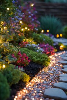 the pathway is lit up with fairy lights and flowers on it's sides, along with small stepping stones