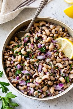 a bowl filled with beans, onions and cilantro on top of a table