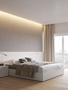 a large white bed sitting in a bedroom next to a wall mounted light above it