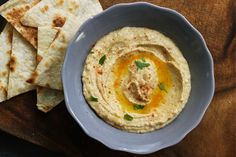 hummus and pita bread on a wooden board