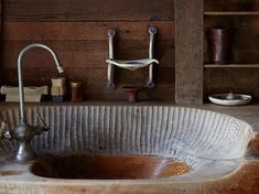 a sink in a rustic bathroom with wooden shelves