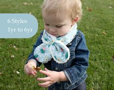 a toddler is holding something in her hand while standing on the grass with it's hands out