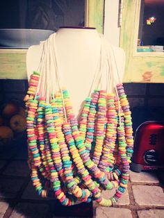 a white mannequin with multicolored necklaces hanging from it's neck