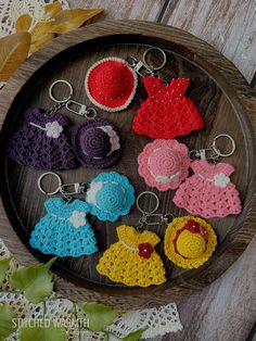 crocheted keychains are arranged on a wooden tray