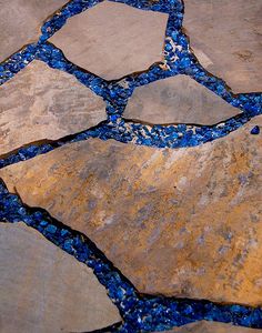 a stone walkway with blue and yellow pebbles