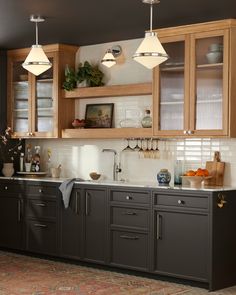 an image of a kitchen with lights above the sink and cupboards on the wall