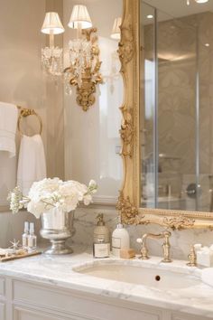 a bathroom with a sink, mirror and chandelier