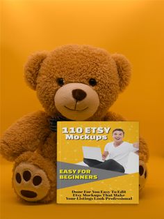 a brown teddy bear sitting next to a yellow background holding a copy of the book easy for beginners