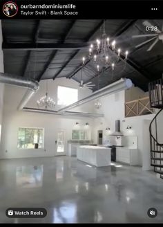 an open floor plan with chandeliers and white cabinets