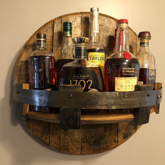 a wooden barrel filled with liquor bottles on top of a wall next to a sign that says christmas sale 50 % off bourbon