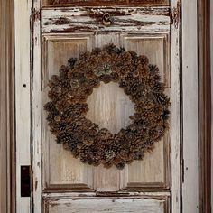 a pine cone wreath on an old door