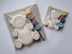 there are two cakes in the shape of teddy bears with buttons on them, one is white and the other is blue