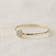 a diamond ring sitting on top of a white cloth