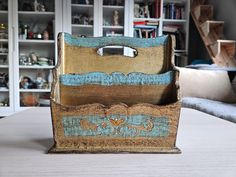 a wooden box sitting on top of a table in front of a book shelf filled with books