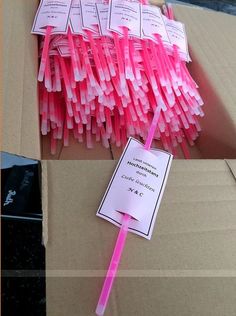 pink toothbrushes are sitting in a box with labels on them and tags attached to the top