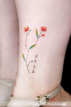 a close up of a person's leg with flowers on it and the word love written in cursive writing