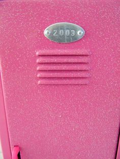 an old pink radio sitting on top of a table