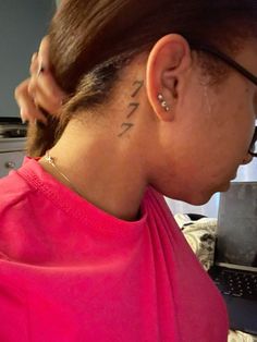 a woman with a tattoo on her neck looking at a laptop computer in front of her