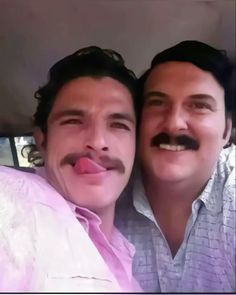 two men with mustaches are sitting in a car