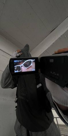 a man holding up a camera to take a picture of something on his cell phone