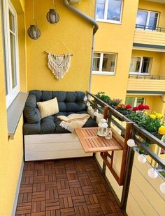 a balcony with a couch, table and potted plants