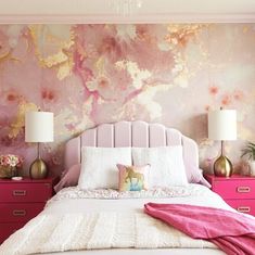 a bedroom with pink and gold wallpaper, white bedding and two nightstands