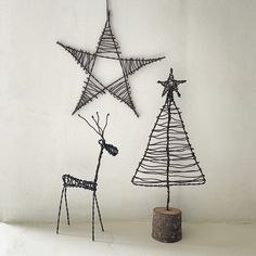 three wire christmas trees with deer and giraffe standing next to each other in front of a white wall