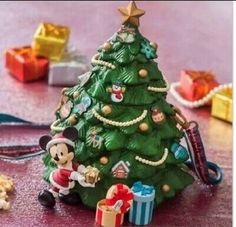 a mickey mouse christmas tree with presents on the floor next to it and other decorations