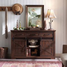 a living room area with a rug, chair and wooden cabinet in it's center