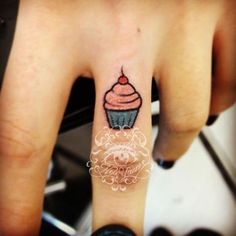 a small cupcake tattoo on the left hand