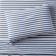 two blue and white striped sheets on top of each other