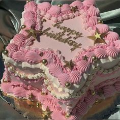 a pink birthday cake with gold stars on it