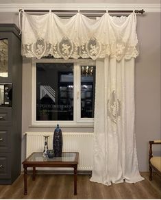 a living room with white curtains and a coffee table