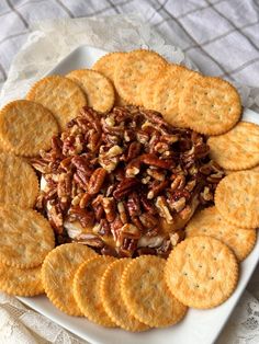 a white plate topped with crackers and nuts