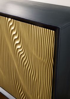 a black and gold cabinet with wavy design