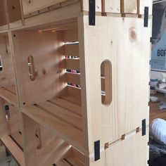 a wooden toy house with shelves and drawers